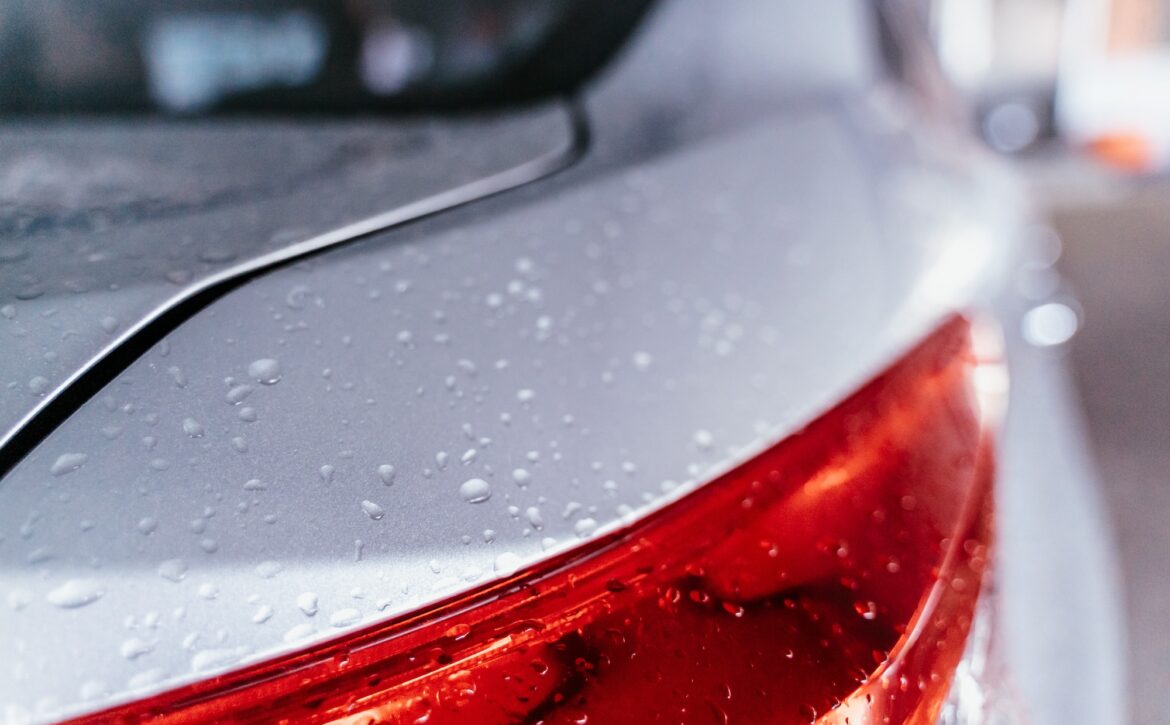 Water droplet on the car hood. Water beading after rain or car wash on white shiny paint surface. Beading created by ceramic coat or paint sealant with high surface tension. Water drop Backgroud.