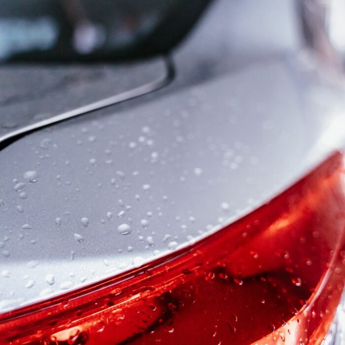 Water droplet on the car hood. Water beading after rain or car wash on white shiny paint surface. Beading created by ceramic coat or paint sealant with high surface tension. Water drop Backgroud.